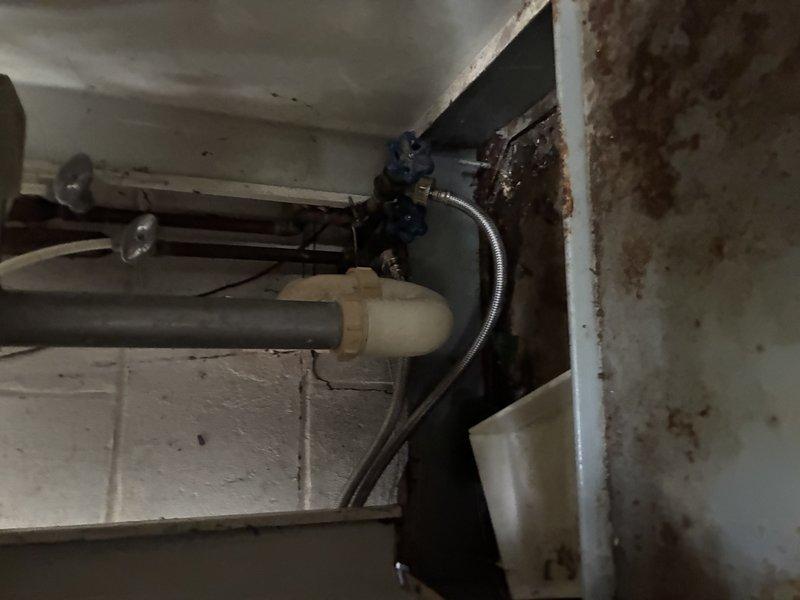 Diagnosed and repaired a ruptured sink drain pipe in the washer area, replacing the failed section to restore proper drainage and eliminate leakage. Inspected the kitchen supply lines and shutoff valves to address the cold-to-hot water crossover, and checked the greenhouse addition faucet and flexible supply connections, noting heavy corrosion on adjacent metal components and aged brass hose fittings.