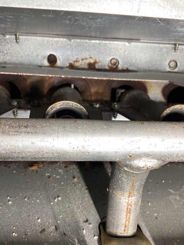 Responded to a no-heat call on a 10+ year old gas furnace and removed the front access panel to inspect the burner assembly, gas manifold, gas valve, and draft inducer. Found surface rust on the gas manifold piping and burner compartment, along with soot and heat discoloration around the burner tubes and debris buildup in the cabinet, indicating combustion and corrosion concerns that need further attention to ensure safe, reliable operation.
