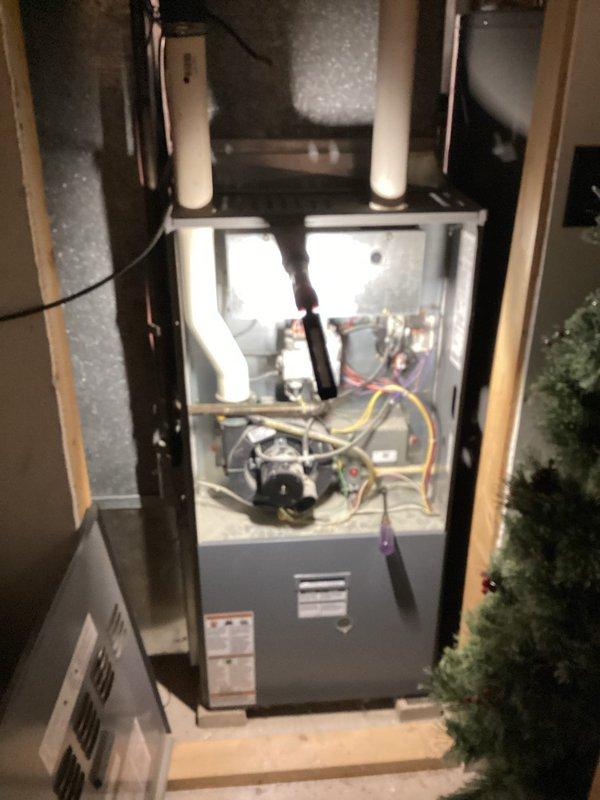 Responded to a no-heat call on a 10+ year old gas furnace and removed the front access panel to inspect the burner assembly, gas manifold, gas valve, and draft inducer. Found surface rust on the gas manifold piping and burner compartment, along with soot and heat discoloration around the burner tubes and debris buildup in the cabinet, indicating combustion and corrosion concerns that need further attention to ensure safe, reliable operation.