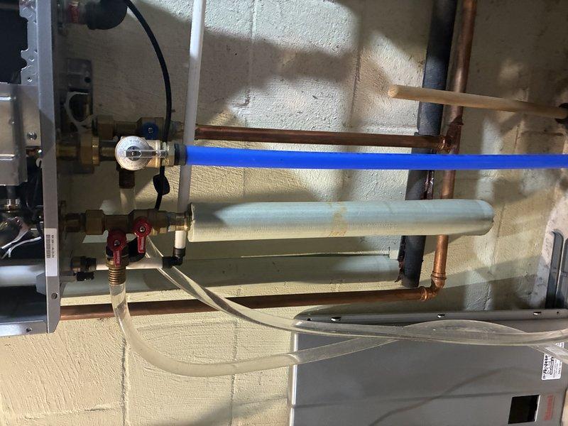 Serviced a natural gas Rinnai tankless water heater (model REU-N3237FF-US) for slow hot water delivery. Connected isolation service valves with hoses and performed a full descaling flush of the heat exchanger to remove mineral buildup restricting flow and heat-up time. Restored the unit to normal operation and verified proper performance.