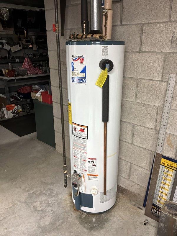 Performed a whole-home plumbing inspection, including the basement sump pit and discharge piping, which has a check valve and shows staining and moisture on the surrounding masonry walls and floor. Inspected the gas-fired water heater and found rust-colored staining and dampness on the floor at the base of the tank, indicating a possible leak or condensation issue that warrants further evaluation. Recommend monitoring the sump system and having the water heater connections and tank condition assessed for repair or replacement.