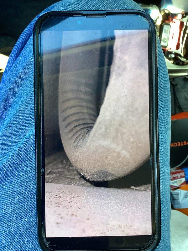 Responded to a no-heat call and inspected the system's flexible ductwork using a borescope, identifying a torn section of the duct's outer jacket and insulation along with dust and debris buildup at a bend in the line. Documented the damaged duct and diagnosed the compromised air distribution as a contributing factor to the loss of heat.