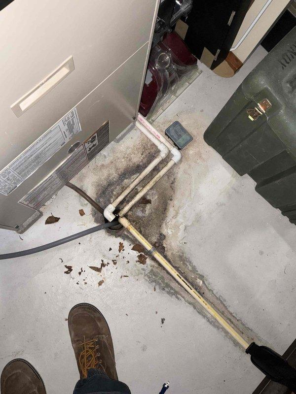 Performed an on-site evaluation of the existing split-system air conditioning installation for a replacement estimate following a failed contactor. Inspected the indoor air handler, refrigerant line set, condensate drainage, and control components in a confined utility closet, and noted heavy staining and moisture residue around the condensate drain piping and secondary drain/safety switch area that should be addressed during replacement. Documented equipment data labels and installation conditions to determine replacement options and scope.