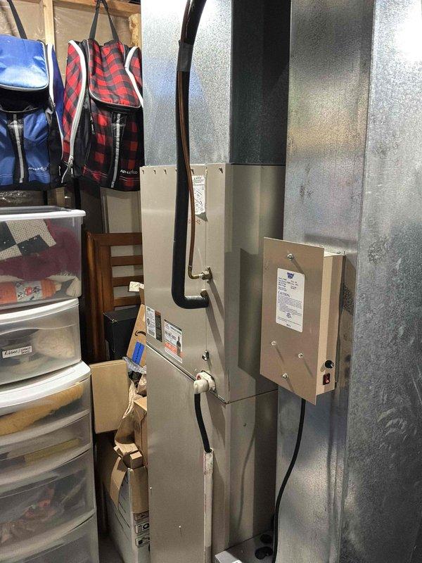 Performed an on-site evaluation of the existing split-system air conditioning installation for a replacement estimate following a failed contactor. Inspected the indoor air handler, refrigerant line set, condensate drainage, and control components in a confined utility closet, and noted heavy staining and moisture residue around the condensate drain piping and secondary drain/safety switch area that should be addressed during replacement. Documented equipment data labels and installation conditions to determine replacement options and scope.