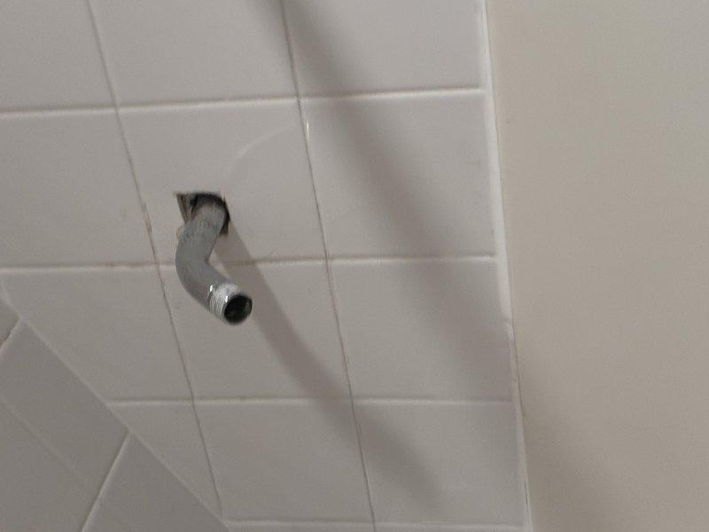 Removed and replaced the existing tub drain assembly, installing a new matte black overflow cover plate and drain stopper, and verified the diverter spout and drain operated properly. Also removed the worn, discolored shower arm and installed a new threaded shower arm at the wall connection, leaving the outlet ready for shower head attachment.