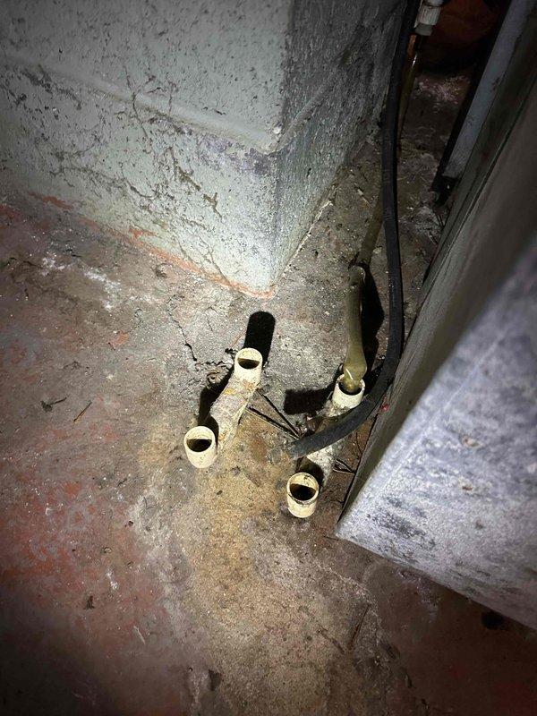 Responded to a non-operational furnace and performed an on-site evaluation of the existing upright gas furnace, plenum, and ductwork in the basement utility area to prepare a replacement estimate. Documented the unit's condition, including the dusty, aged supply plenum and ductwork, the condensate/PVC piping, and the stubbed PVC and corroded metal piping near the base, noting the stained concrete floor and clearance around the equipment for installation planning. Replacement recommendations were prepared based on the findings.