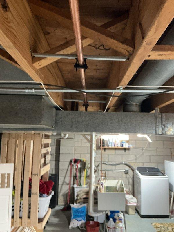 Repaired the water main by replacing approximately 20 feet of copper supply piping, with the water supply shut off for the duration of the work. The new copper run was secured to the floor joists with strut brackets and clamps, and the system was left properly supported and ready for service.