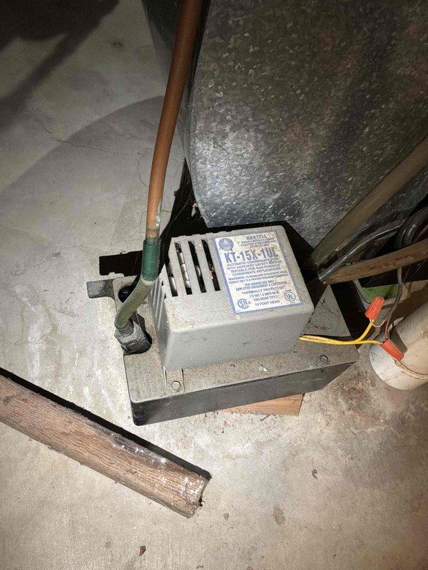 Performed a replacement estimate evaluation of the existing 36-year-old natural gas furnace located in the basement and the 19-year-old outdoor air conditioning condenser. The condenser exhibited heavily soiled, discolored coil surfaces with rust along the cabinet base and grate, and was surrounded by overgrown vegetation and debris restricting airflow. The condensate pump in the basement showed a corroded copper line at its inlet fitting, along with visible dust and debris buildup, and both systems were documented as candidates for replacement due to age and condition.