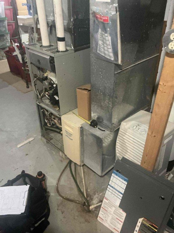 Performed on-site evaluation for replacement of a non-operational forced-air natural gas furnace and AC system serving a 2,400 sq ft, two-story home. The furnace is located in the basement with no equipment in the attic or crawl space; inspected the unit with the access panel removed, documented the existing plenum, ductwork, PVC venting/condensate piping, and exterior pipe termination, and took measurements to determine replacement equipment sizing and installation requirements.