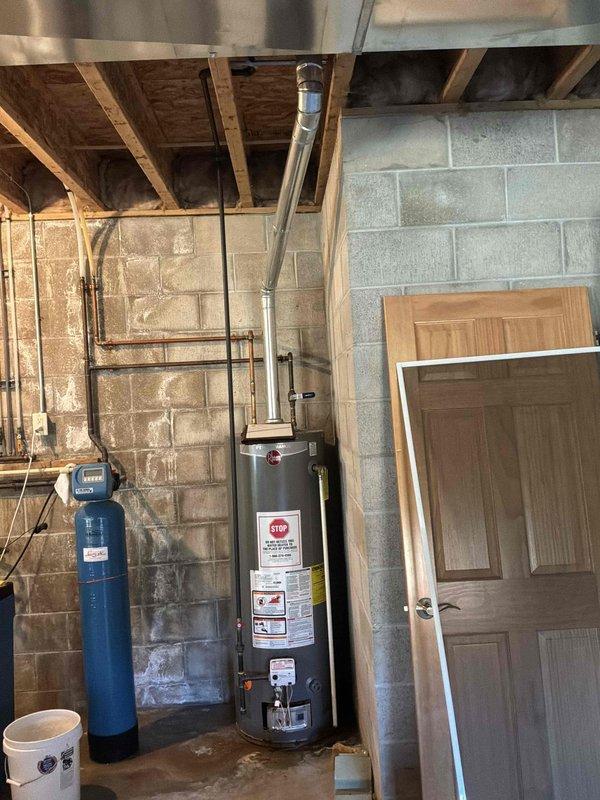 Inspected a leaking 50-gallon atmospheric-vent gas water heater and found moisture and staining at the base of the tank, indicating internal tank failure. Evaluated the existing installation, including the flue venting, gas control and burner assembly, and supply piping, and assessed the surrounding area for replacement. Prepared a replacement estimate for a new 50-gallon gas water heater.