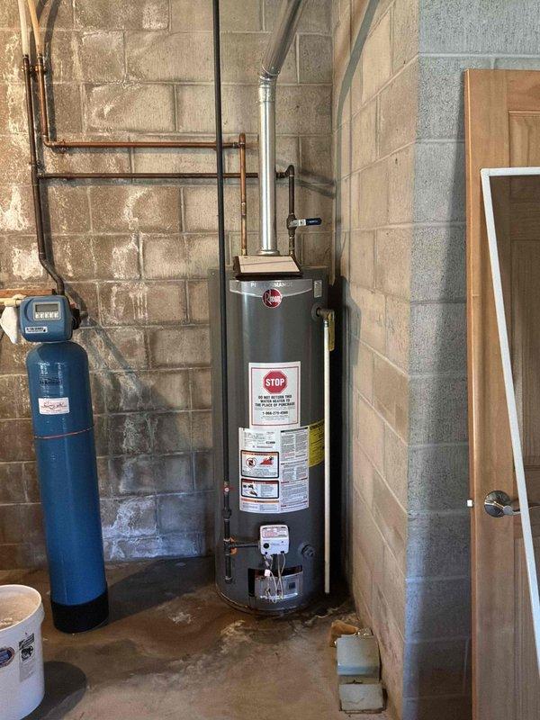 Inspected a leaking 50-gallon atmospheric-vent gas water heater and found moisture and staining at the base of the tank, indicating internal tank failure. Evaluated the existing installation, including the flue venting, gas control and burner assembly, and supply piping, and assessed the surrounding area for replacement. Prepared a replacement estimate for a new 50-gallon gas water heater.