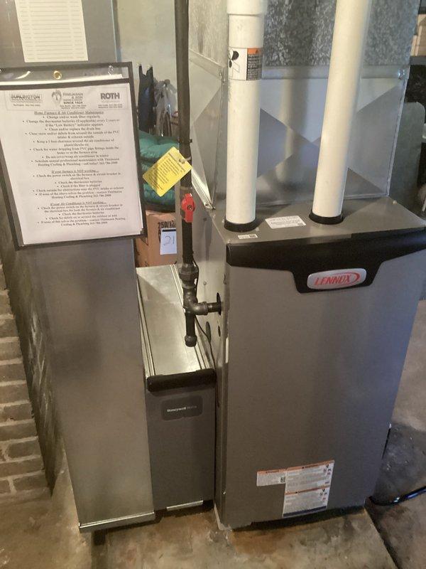 Installed a new Lennox gas furnace on a raised concrete pad in the basement, connecting the PVC intake/exhaust venting to the plenum and ductwork and tying into the existing black iron gas supply with a shutoff valve. Completed the electrical connections and condensate drain routing under permit, with a licensed electrician involved, then affixed the required rating and warning labels and posted contractor and maintenance information at the unit.