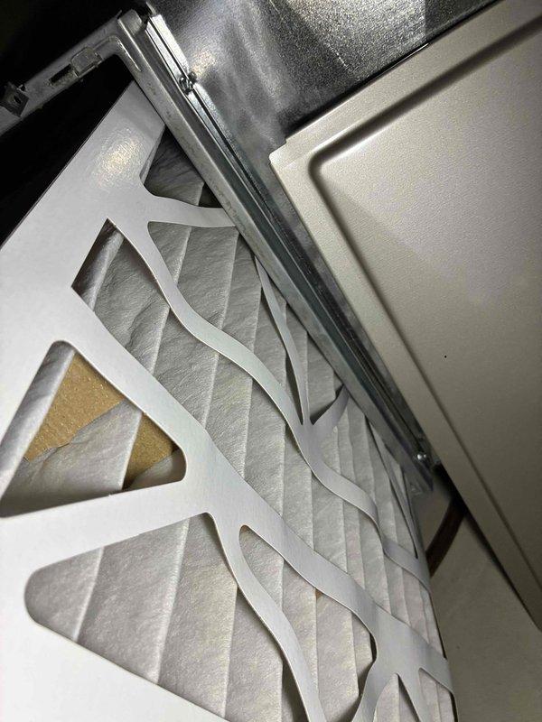 Performed a furnace tune-up, inspecting the air filter in its housing and finding it in serviceable condition with light, even loading and a minor exposed cardboard edge on the frame. Conducted electrical diagnostics with a true RMS clamp meter, measuring a resistance reading of 54.24 ohms to verify component integrity. The unit was left operating properly at completion of the service.