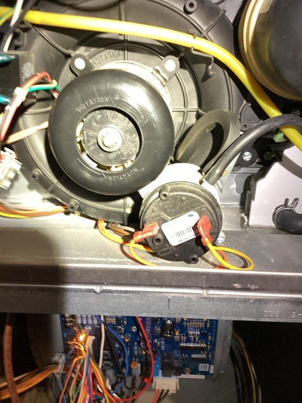 Responded to a no-heat call on a Bryant gas furnace (approx. 9 years old) displaying a flashing yellow status LED. Inspected the draft inducer assembly, pressure switch and hose connections, and control board; components appeared intact but dusty, with minor rust staining noted on the cabinet floor near the inducer drain hose and grommet, indicating possible condensate or moisture intrusion. Warranty coverage was reviewed on site, and further diagnosis of the flame-sequence fault code and condensate path is recommended.