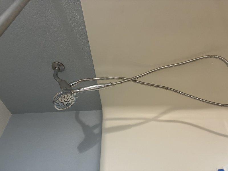 Installed a new tub spout, a customer-supplied post-temperature valve trim kit, and a new handheld showerhead with a flexible stainless steel hose. Sealed the spout base with caulk and verified all fixtures were secure, with no leaks and proper operation of the diverter and temperature control.