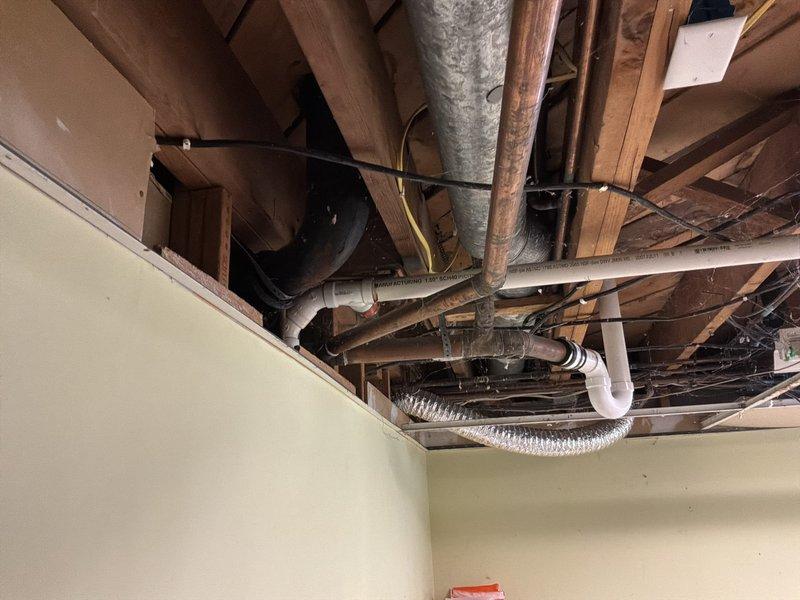 Completed a whole-home plumbing inspection, visually assessing accessible supply and drain piping, including copper supply lines, PVC and ABS drain piping with rubber couplings, and fittings through an open ceiling cavity. Noted staining on concrete block walls and dust accumulation on piping, with no active leaks observed in the documented areas, and photographed all inspected components for the service record.