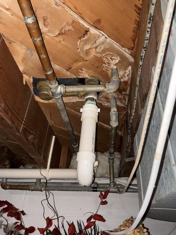 Performed an on-site estimate for installation of a new shower fixture and evaluation of the existing shower faucet and cold water supply valve on a single tub/shower unit. Inspected the chrome single-handle valve, tub spout, and diverter, with no visible rust, buildup, or damage, and reviewed the basement supply and drain piping, noting mixed copper and galvanized/iron piping with brass fittings, a PVC drain with cleanout, and heavily stained, deteriorated floor joists and subflooring from prior water exposure. Reviewed repair and replacement options on site; same-day repair was not guaranteed pending technician assessment.