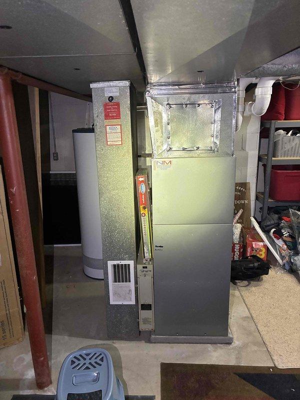 Performed an on-site estimate for replacement of a 15-year-old forced-air heating system located in the basement utility area. Inspected the existing upright furnace/air handler, supply and return ductwork, and surrounding clearances to evaluate replacement requirements and confirm the system fuel source, with natural gas service verified to the property. Documented the unit and installation area with photos to support a replacement quote.