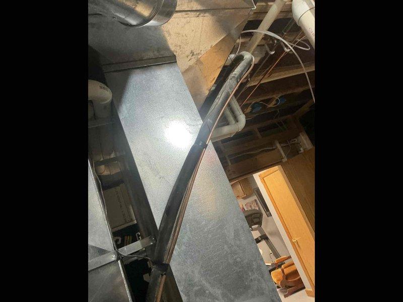 Performed an on-site estimate for an air conditioning system replacement, inspecting the basement-mounted ductwork, refrigerant line set, and condensate drain piping. Existing galvanized supply trunk, insulated refrigerant lines, and PVC condensate drain were found in serviceable condition with no visible frost, rust, or damage. Customer elected to pour the equipment slab before proceeding with the replacement installation.