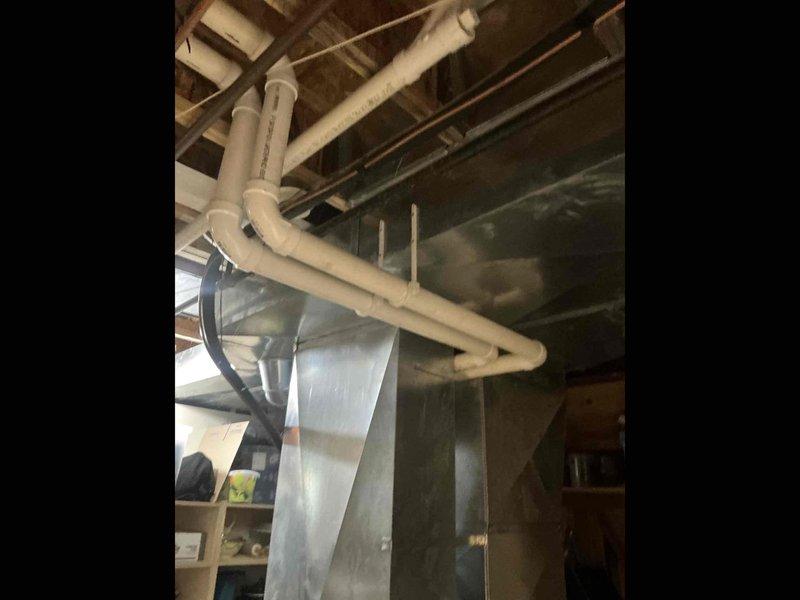 Performed an on-site estimate for an air conditioning system replacement, inspecting the basement-mounted ductwork, refrigerant line set, and condensate drain piping. Existing galvanized supply trunk, insulated refrigerant lines, and PVC condensate drain were found in serviceable condition with no visible frost, rust, or damage. Customer elected to pour the equipment slab before proceeding with the replacement installation.