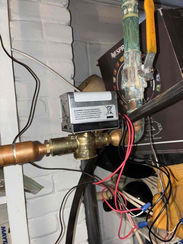 Responded to a hot water boiler heating complaint and inspected the basement-installed boiler system, including the zone valve and actuator wiring, supply piping, and gas piping. Observed heavy corrosion and mineral buildup on piping above the zone valve and rust on the gas line union fitting, both of which are noted as conditions requiring further evaluation. Documented system conditions with photos for the service record.