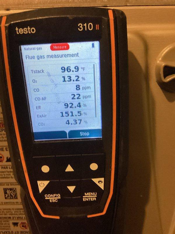 Performed a furnace tune-up with the upper access panel removed to inspect the draft inducer assembly, gas valve, wiring connections, and PVC venting. Conducted combustion analysis on the natural gas appliance with a flue gas analyzer, recording a stack temperature of 96.9°F, O2 at 13.2%, CO at 8 ppm (22 ppm air-free), CO2 at 4.37%, and a steady-state efficiency of 92.4%, indicating safe and efficient operation within normal parameters.