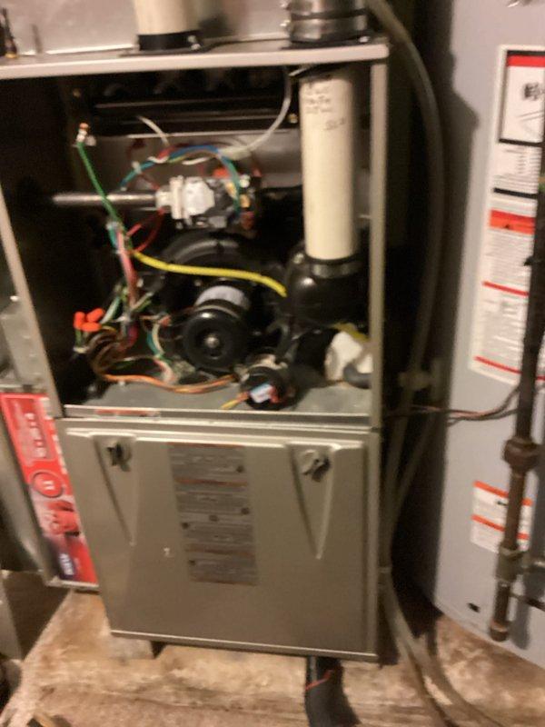 Performed a furnace tune-up with the upper access panel removed to inspect the draft inducer assembly, gas valve, wiring connections, and PVC venting. Conducted combustion analysis on the natural gas appliance with a flue gas analyzer, recording a stack temperature of 96.9°F, O2 at 13.2%, CO at 8 ppm (22 ppm air-free), CO2 at 4.37%, and a steady-state efficiency of 92.4%, indicating safe and efficient operation within normal parameters.