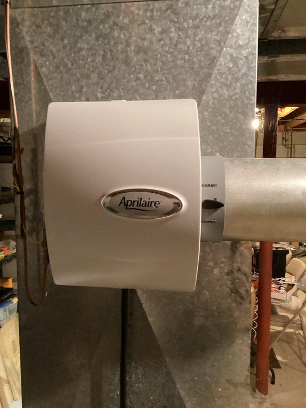 Performed a furnace tune-up, including inspection of the heating system and replacement of the furnace filter. Serviced the Aprilaire whole-home humidifier by replacing the water panel (humidifier pad) and verifying the bypass damper was set to the summer position. Updated the service log label on the supply plenum to record the visit.