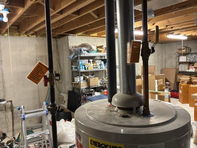 Performed an on-site estimate for water heater replacement, evaluating options for customer-supplied or contractor-supplied unit installation. Inspected the existing gas-fired tank-type water heater, including the galvanized flue, gas supply with shutoff valve, copper water lines, and surrounding basement piping and ductwork, and found no visible corrosion, leaks, or damage. Documented existing conditions and clearances to determine the scope of work for installation.