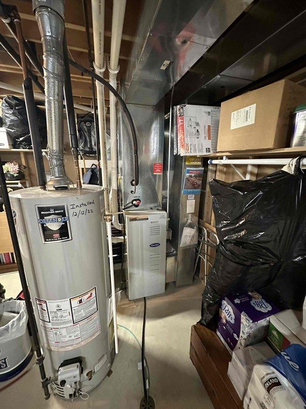 Performed an on-site estimate for replacement of the furnace and air conditioning system; the existing 24-year-old equipment is operational but at the end of its expected service life. Inspected the outdoor condenser, which shows heavy corrosion on the fan guard and fan hub, a weathered and uneven mounting pad, and debris accumulation around the unit, and evaluated the Carrier gas furnace, ductwork, and surrounding utility space for replacement equipment sizing and installation requirements. Documented equipment conditions with photographs, including the electrical disconnect, flexible conduit connection, and unit data plate, in preparation for system replacement recommendations.
