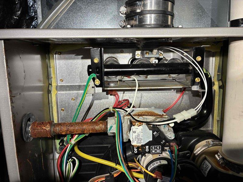 Responded to a no-heat complaint where the furnace initiates a heat cycle but shuts off prematurely. Inspected the burner compartment and found significant corrosion on the gas supply piping, gas valve fitting, and cabinet floor, indicating moisture exposure or condensate-related issues. Verified the ignition sequence, flame sensing, and pressure switch/inducer operation to identify the cause of the cycling failure, and documented the corrosion findings with photos for further evaluation.