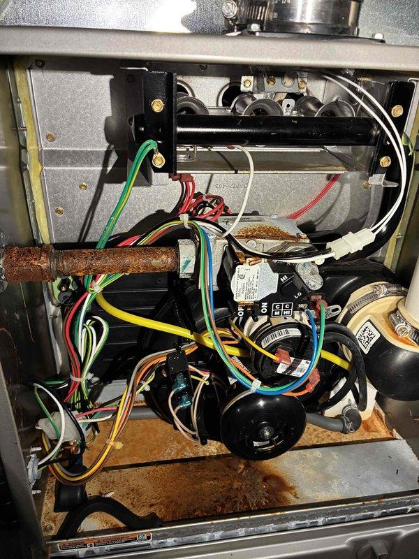 Responded to a no-heat complaint where the furnace initiates a heat cycle but shuts off prematurely. Inspected the burner compartment and found significant corrosion on the gas supply piping, gas valve fitting, and cabinet floor, indicating moisture exposure or condensate-related issues. Verified the ignition sequence, flame sensing, and pressure switch/inducer operation to identify the cause of the cycling failure, and documented the corrosion findings with photos for further evaluation.
