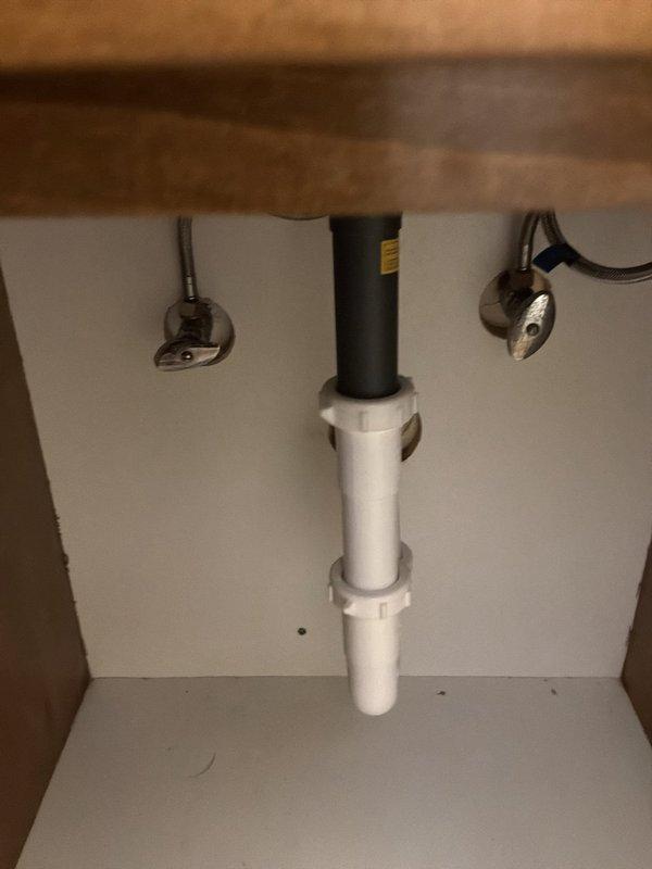 Inspected the bathroom vanity and evaluated the plugged faucet spout, the bathroom fixture shutoff valves, and several outdoor faucets requiring new gaskets. The angle-stop valves and braided supply lines beneath the sink showed no visible leaks or corrosion, and the drain assembly appeared intact, with mineral staining noted around the basin drain. Scope of work was assessed for the spout clearing, shutoff valve service, and outdoor faucet gasket replacement.