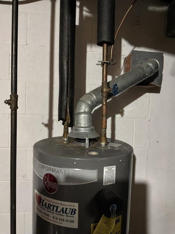 Assessed the existing 40-gallon gas water heater, which has a leaking shut-off valve at the top of the tank, and prepared an estimate for replacement with a 50-gallon gas atmospheric (gravity-vent) unit. The scope includes a new thermal expansion tank with arm, a 3/4" press ball valve, a 1/2" gas valve, and 3/4" Type L copper press fittings and piping, with the existing vent connection and pipe insulation to be reviewed and reinstalled during the changeout.