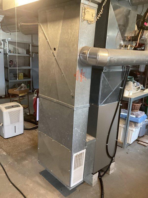 Installed a new upright gas furnace with a new thermostat, reusing the existing filter cabinet and adapting the new unit to the existing solid-core PVC venting. Reconnected the supply plenum and ductwork, set the furnace on elevated concrete blocks, and wired the control components, with permit obtained and electrical work completed. Unit is operating properly, with warning and rating labels, installation documentation, and the Honeywell control in place.