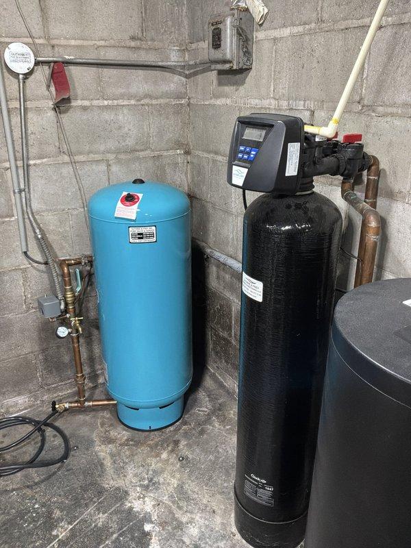 Performed on-site evaluation and provided estimates for water heater replacement and additional water line repair. Inspected the utility room's existing equipment, including the pressure tank with copper piping, pressure switch and gauge, the water treatment tank with digital control head, and the large blue sediment filter with insulated supply piping showing wear and loose insulation. Documented system conditions with photos to support the replacement scope and recommended water line repairs.