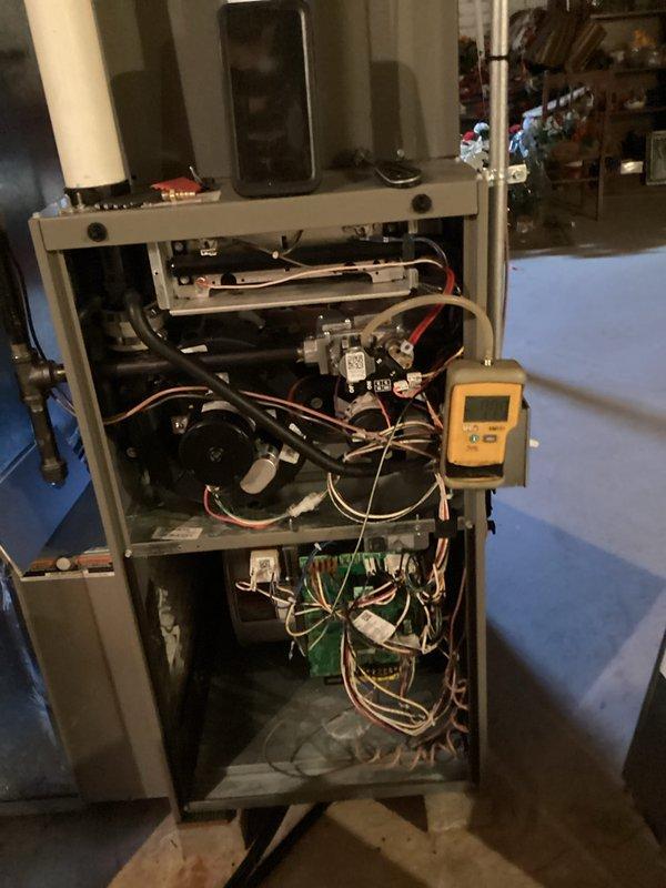 Performed a furnace tune-up with access panels removed to inspect the burner assembly, gas valve, inducer motor, control board, and wiring harness. Verified gas manifold pressure using a digital manometer and tested electrical components with a multimeter to confirm proper operation. Documented the furnace's internal condition, including loose and unsecured wiring in the control compartment.
