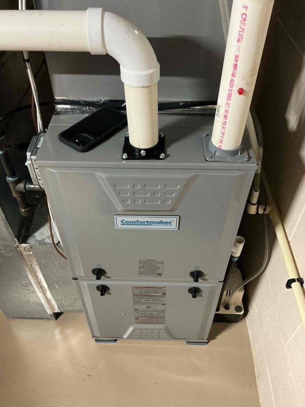 Performed diagnostic evaluation of a Comfortmaker gas furnace for a reported condensate pump malfunction, inspecting the condensate drain line, PVC vent and intake piping, and collector box assembly. Verified the pump and associated drain tubing were properly routed and in serviceable condition, with no visible damage, corrosion, or frost on the unit or its connections.