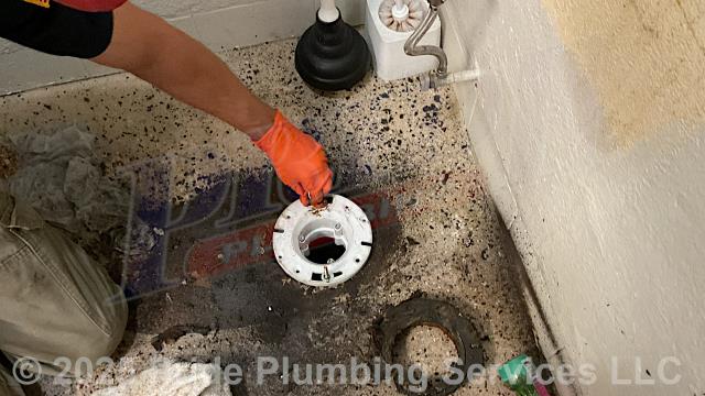 Pride Plumbing was called out for a clogged drain line in the laundry room. We used a sewer machine down through the drain and cleared the blockage. The customer also wanted us to look at a loose toilet. We pulled the toilet; cleaned the wax ring gasket off; found that the closet flange was broken and ground it off; installed a new Oatey 43539 PVC replacement closet flange; installed a new wax ring gasket; replaced the toilet bolts and caps; reset the toilet; added six plastic shims underneath the toilet bowl to level it; tested for leaks; caulked around the base of the toilet bowl; and tested for stability, leaks and proper operation with no issues. We also provided a cost estimate to trench a ditch from the town sewer tap to the building to expose and replace the main outside sewer septic drain line with new PVC piping and fittings along with installing proper cleanouts and fittings per code.