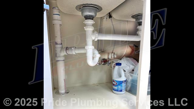 Pride Plumbing came out and performed the following work: 1) drilled through the floor inside a breakroom's double-sink cabinet; 2) connected new PVC piping to the building's main drain stack underneath the building and ran it up through the floor and up to the sink, adding a new P-trap, drain assembly, and air admittance valve; 3) inserted a drain snake into the sink's drain to clear it of any blockages; 4) inserted the drain snake down through a sink in the dental assistant's area and cleared a blockage in it; and 5) tested all the drains for proper drainage with no further issues.