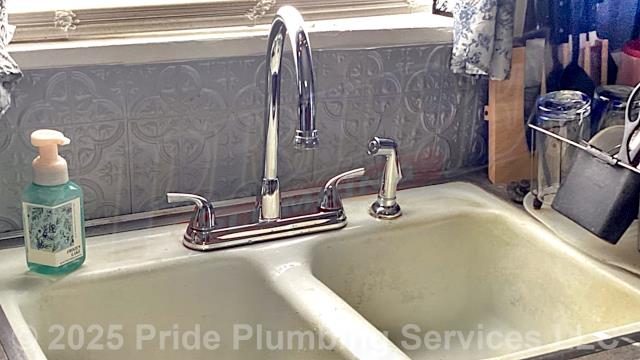 Pride Plumbing was called out for a broken handle on the hot side of a two-handle kitchen sink faucet. We replaced the faucet with a new customer-supplied two-handle model with a sprayer. This included removing the old faucet, mounting the new faucet, connecting the sprayer, and replacing the hot and cold above-floor water supply lines underneath the sink with new braided stainless-steel ones and connecting them to the water supply stops and faucet.