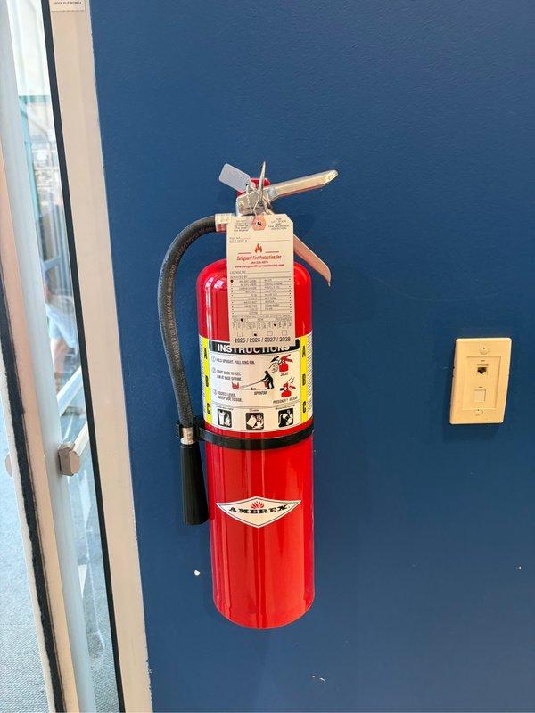 Performed annual inspection and maintenance service on two fire extinguishers located in commercial facility. Conducted thorough visual inspection of wall-mounted ABC dry chemical extinguisher in interior corridor, verifying proper mounting bracket security, gauge pressure readings within acceptable green zone parameters, and legibility of instruction labels and certification markings. Inspected vehicle-mounted fire extinguisher, confirmed pressure gauge reading within operational range, verified mounting bracket integrity, and attached new inspection tag documenting service completion and compliance with State Fire Marshal requirements.