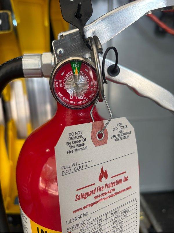 Performed annual inspection and maintenance service on two fire extinguishers located in commercial facility. Conducted thorough visual inspection of wall-mounted ABC dry chemical extinguisher in interior corridor, verifying proper mounting bracket security, gauge pressure readings within acceptable green zone parameters, and legibility of instruction labels and certification markings. Inspected vehicle-mounted fire extinguisher, confirmed pressure gauge reading within operational range, verified mounting bracket integrity, and attached new inspection tag documenting service completion and compliance with State Fire Marshal requirements.