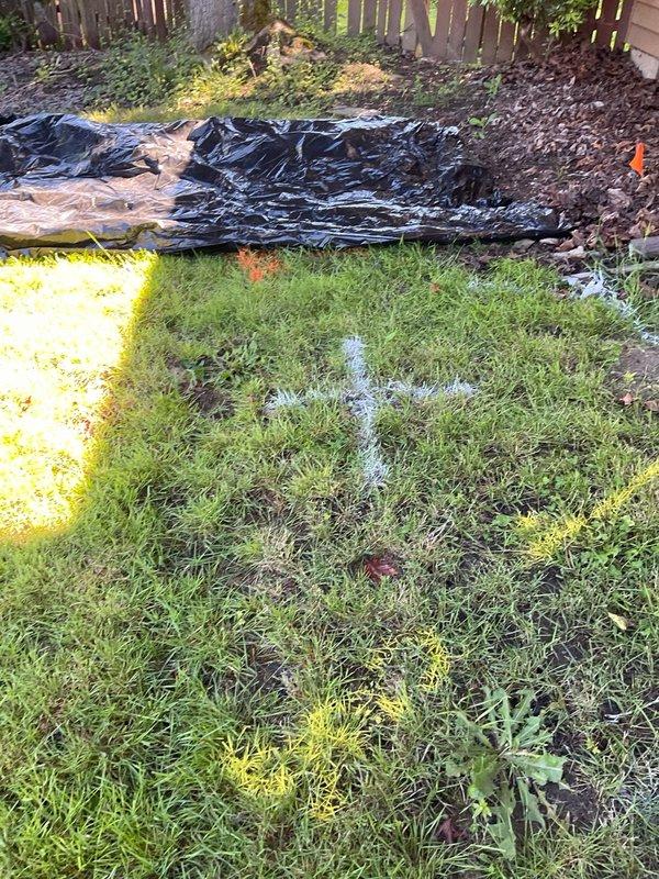 Completed sewer scope inspection of residential property with utility lines marked for excavation. Documentation captured existing conditions including exposed PVC sewer line during excavation work, with proper identification markings visible on pipe. Photographic evidence collected showing pre-work site conditions and active excavation revealing main sewer line routing through backyard area.