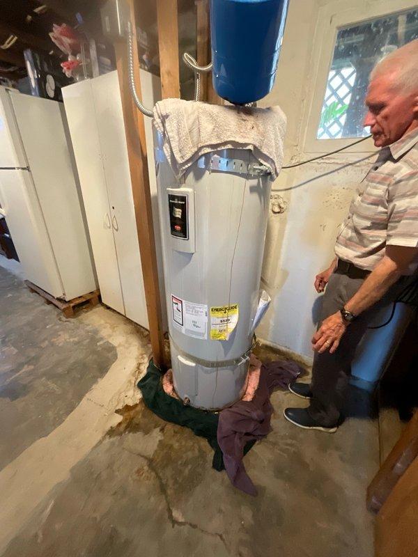 Responded to service call for leaking electric water heater at rental property. Upon arrival, performed visual inspection of unit and surrounding area, noting moisture staining on concrete floor around base of water heater. Assessed existing installation including water heater, overhead blue expansion tank, copper piping connections, and associated plumbing components. Documented current equipment condition and configuration through photographs for estimate purposes. Identified source of leak and evaluated extent of water damage to determine appropriate replacement recommendations. Provided customer with detailed estimate for complete water heater replacement including removal of existing unit, installation of new tanked electric water heater, and all necessary connections to existing plumbing system.
