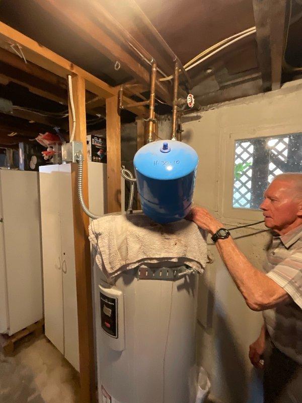 Responded to service call for leaking electric water heater at rental property. Upon arrival, performed visual inspection of unit and surrounding area, noting moisture staining on concrete floor around base of water heater. Assessed existing installation including water heater, overhead blue expansion tank, copper piping connections, and associated plumbing components. Documented current equipment condition and configuration through photographs for estimate purposes. Identified source of leak and evaluated extent of water damage to determine appropriate replacement recommendations. Provided customer with detailed estimate for complete water heater replacement including removal of existing unit, installation of new tanked electric water heater, and all necessary connections to existing plumbing system.