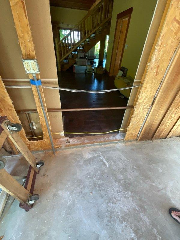 Responded to referral request to assess water pipe relocation required for new door installation in preparation for home sale. Conducted on-site diagnostic evaluation of existing plumbing configuration in unfinished basement area where copper water line conflicts with planned door framing. Documented current pipe routing through photo documentation showing transition between finished living space and construction zone. Identified supply line requiring rerouting to accommodate new door installation without compromising water distribution system integrity.