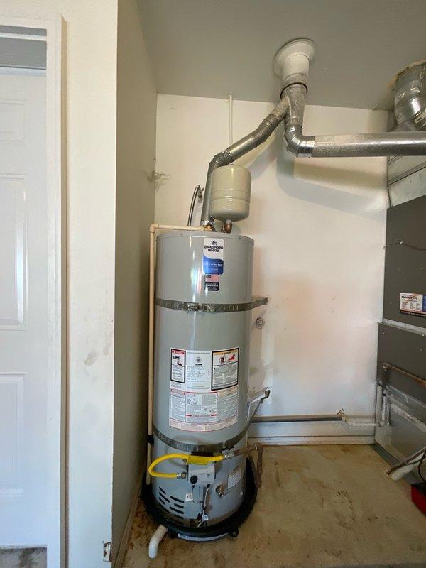 Responded to service call for non-operational gas water heater at rental property. Conducted on-site inspection and assessment of existing GE brand tanked gas water heater unit, documenting current installation configuration including venting system, gas line connections, expansion tank, safety strapping, and all associated plumbing connections. Photographed equipment and provided estimate for water heater replacement to property owner for approval.