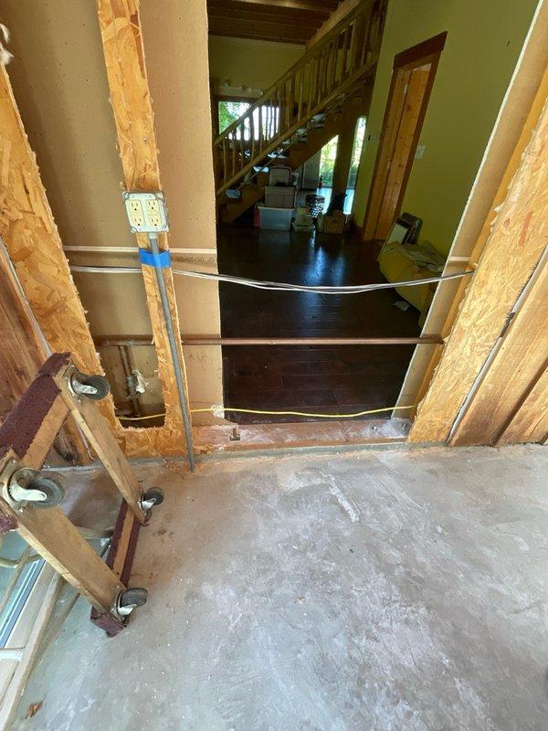Completed diagnostic evaluation of plumbing infrastructure in residential renovation area. Documented existing conditions including exposed copper supply lines showing corrosion, shutoff valve assembly, flexible gas line routing, and vertical drainage piping. Photographed current state of rough plumbing installation and framing work for reference per scope outlined in estimate.