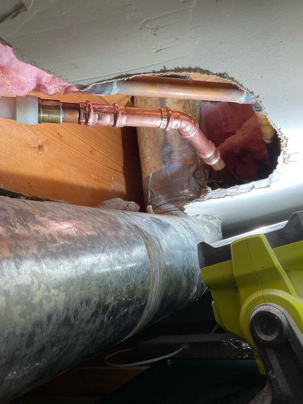 Responded to report of leaking copper pipe in ceiling with drywall already opened for access. Upon arrival, performed visual inspection of exposed plumbing system through existing access opening. Documented conditions with photographs showing copper supply lines, fittings, and connections in ceiling cavity between floor joists. Observed heavily corroded cylindrical component in immediate vicinity of copper piping, along with insulated pipes showing deterioration and discoloration. Assessed joint integrity of visible copper elbows and connections. Evaluated overall condition of plumbing infrastructure and identified potential leak sources. Provided complimentary diagnostic assessment of accessible plumbing components and discussed findings with homeowner.
